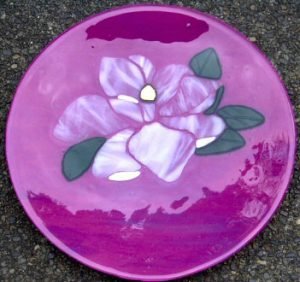 MAGNOLIA WHISPERS Deep pink 14" platter with light lavender streaks and aventurine green leaves. The magnolia is streaky white and clear. The stamen is dichroic gold and green.
